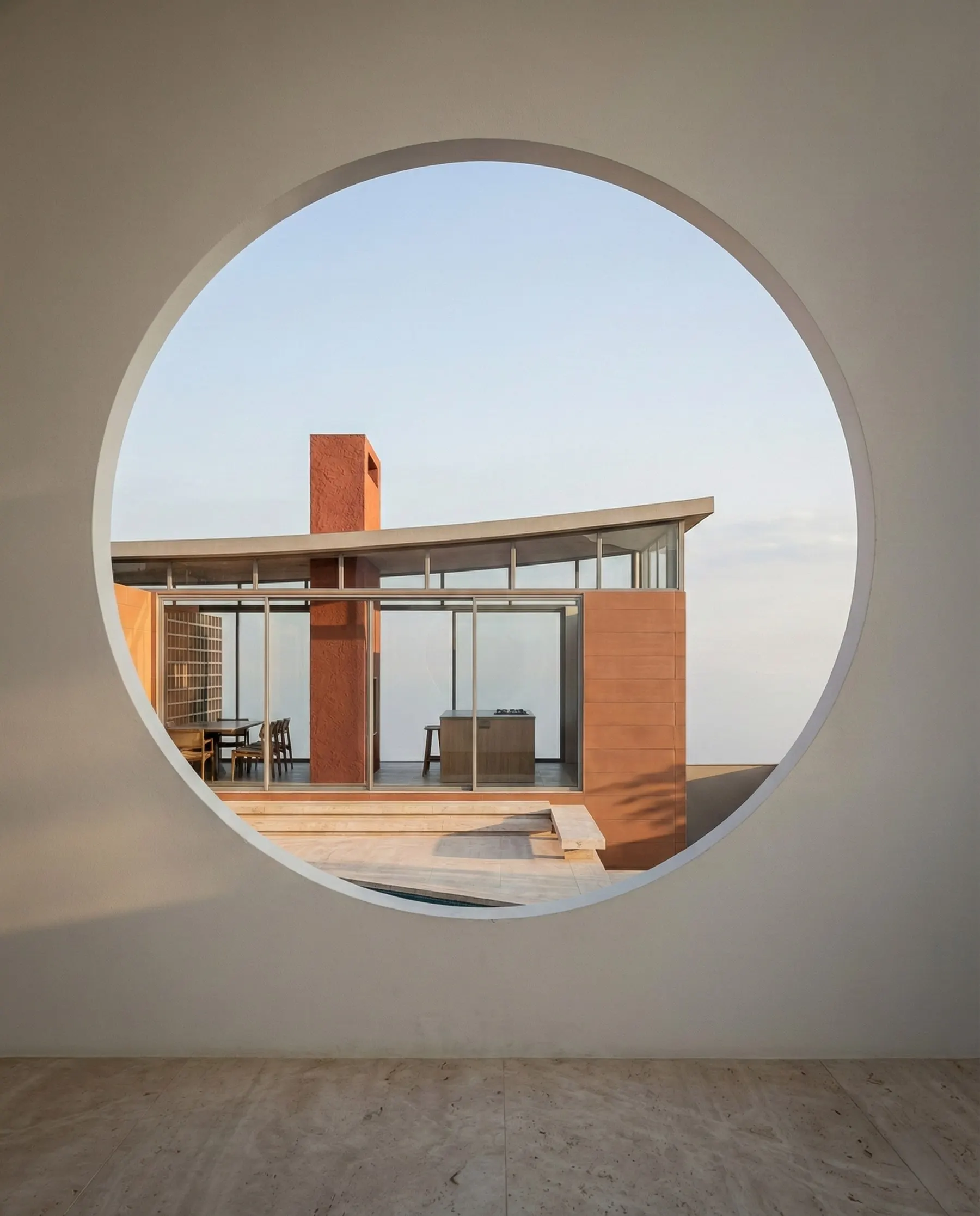 A abertura circular enquadra a casa vista da garagem