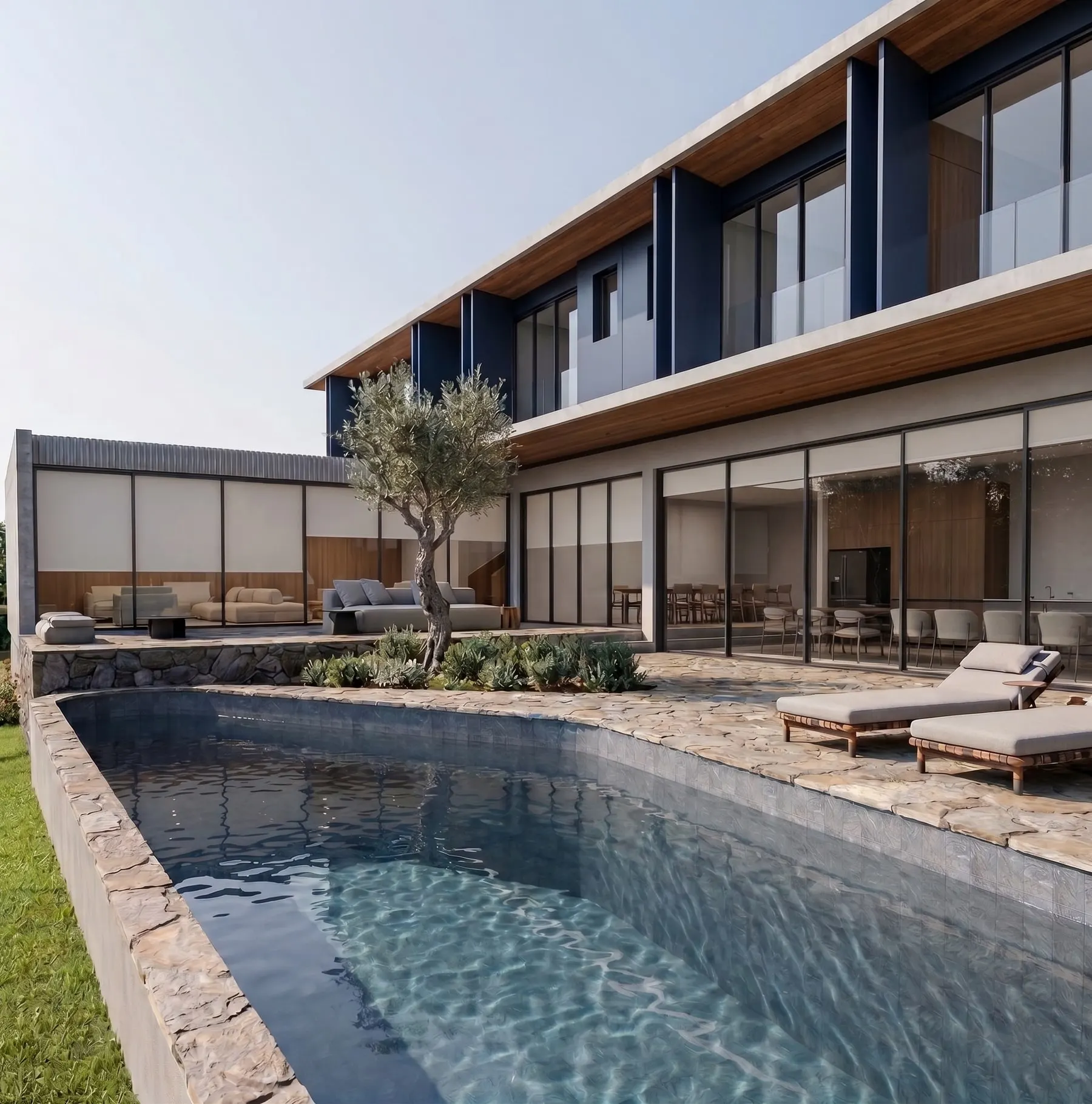 Piscina com borda de pedra voltada para a casa