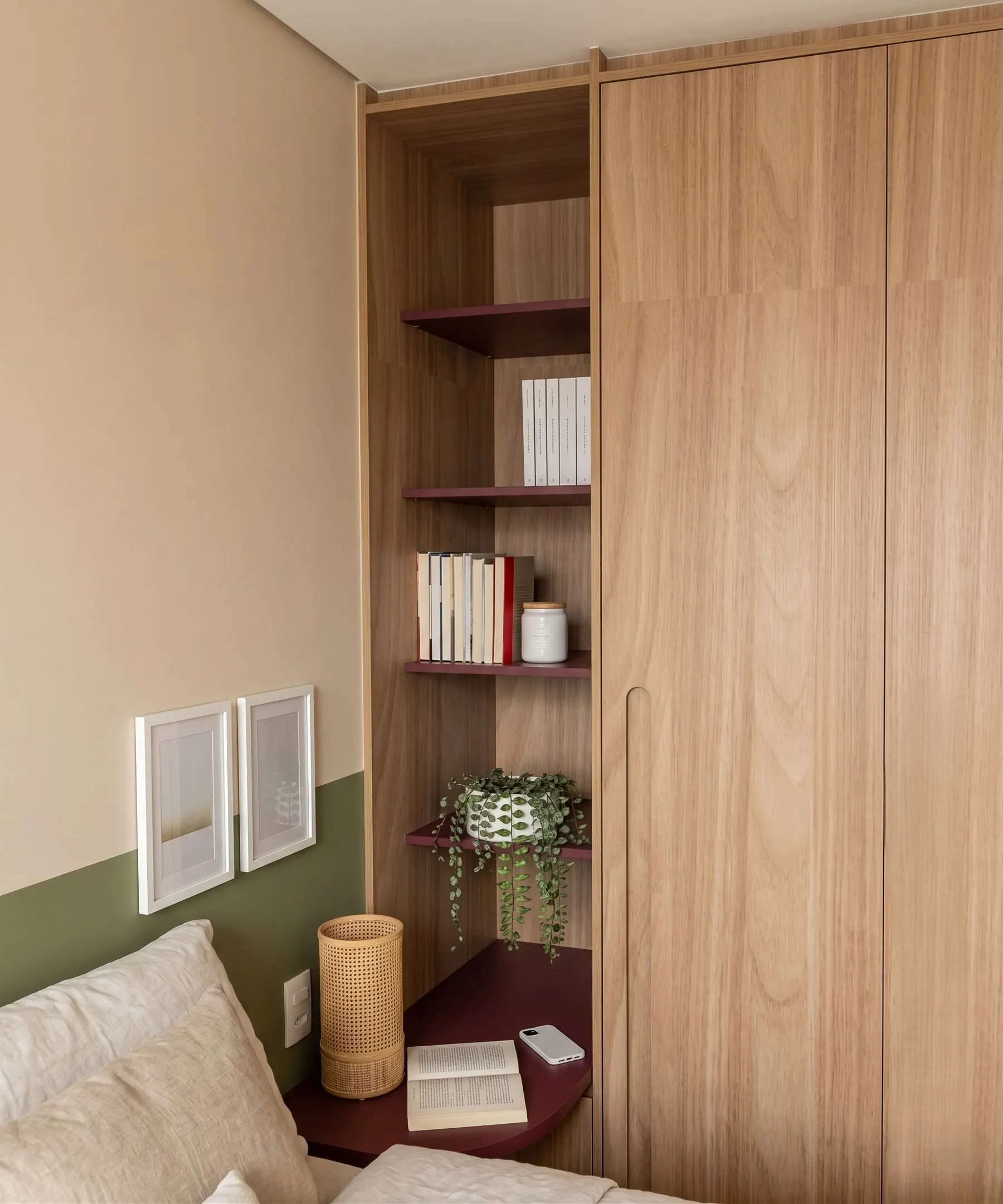 Estante e roupeiro em madeira no quarto, com meia-parede verde